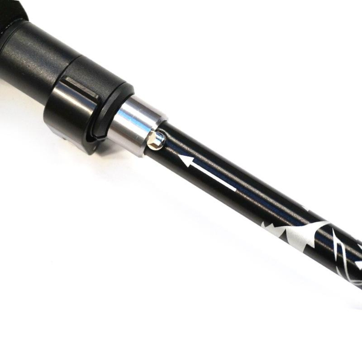 Zbliżenie czarnego kija trekkingowego z białą strzałką.