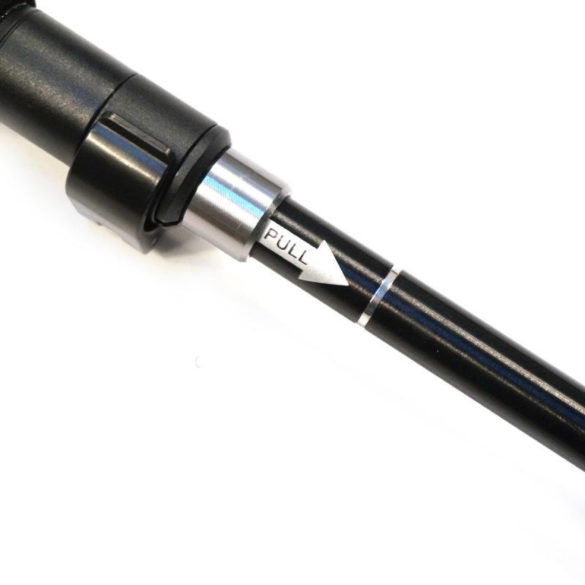 Czarny i srebrny odcinek kija trekkingowego. Słowo "PULL" jest widoczne ze strzałką.