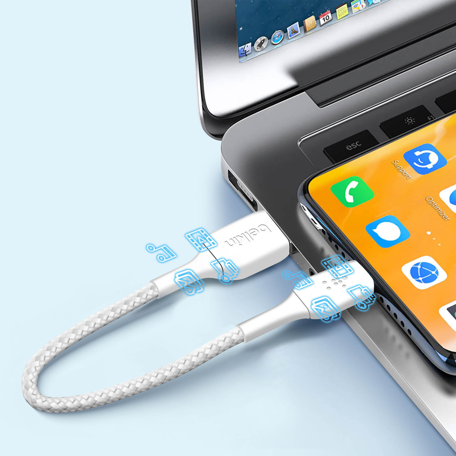 Witte Belkin oplaadkabel aangesloten op laptop en telefoon. Blauwe pictogrammen op kabel.