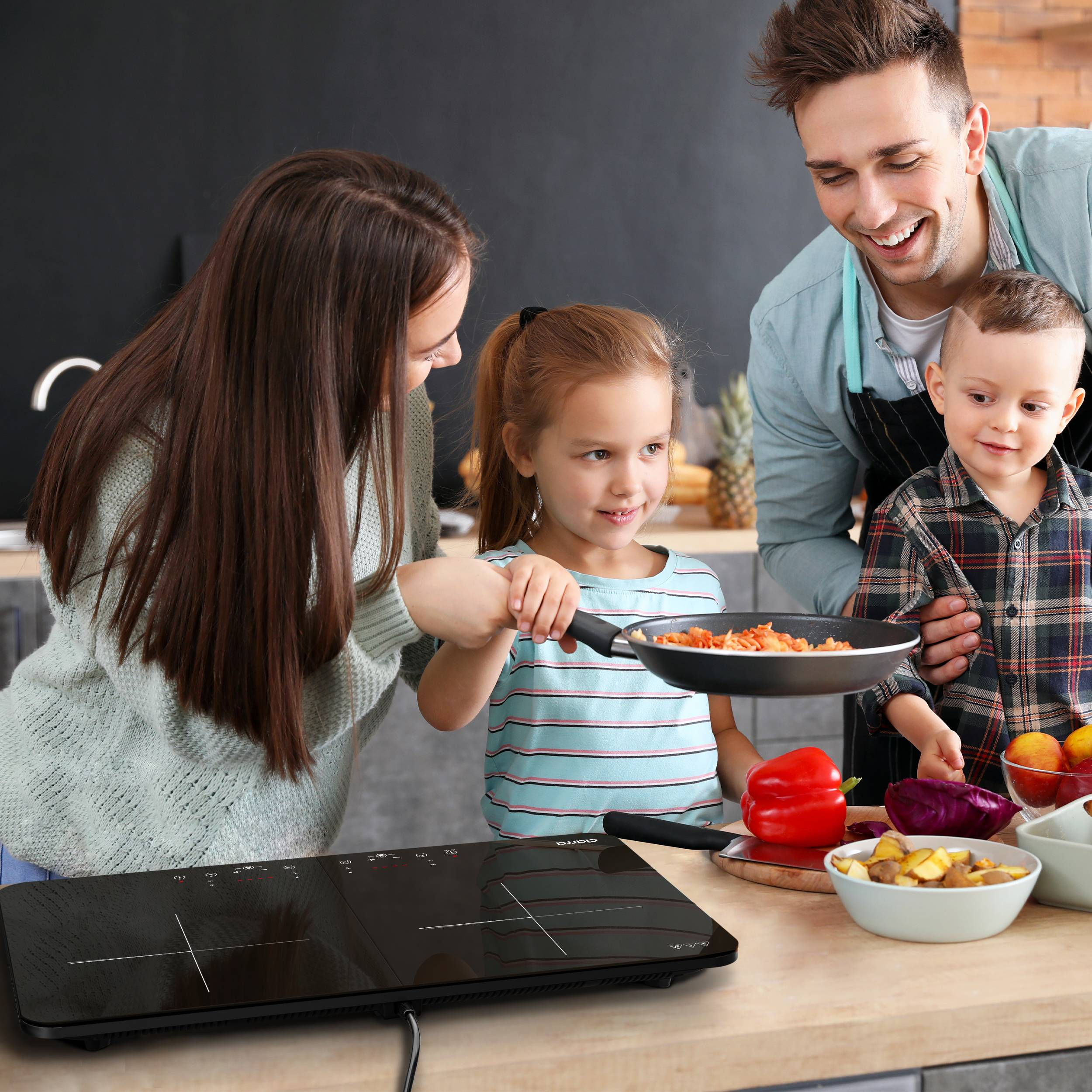 Familie kocht zusammen. Zeigt die Eltern und zwei Kinder in einer Küche.