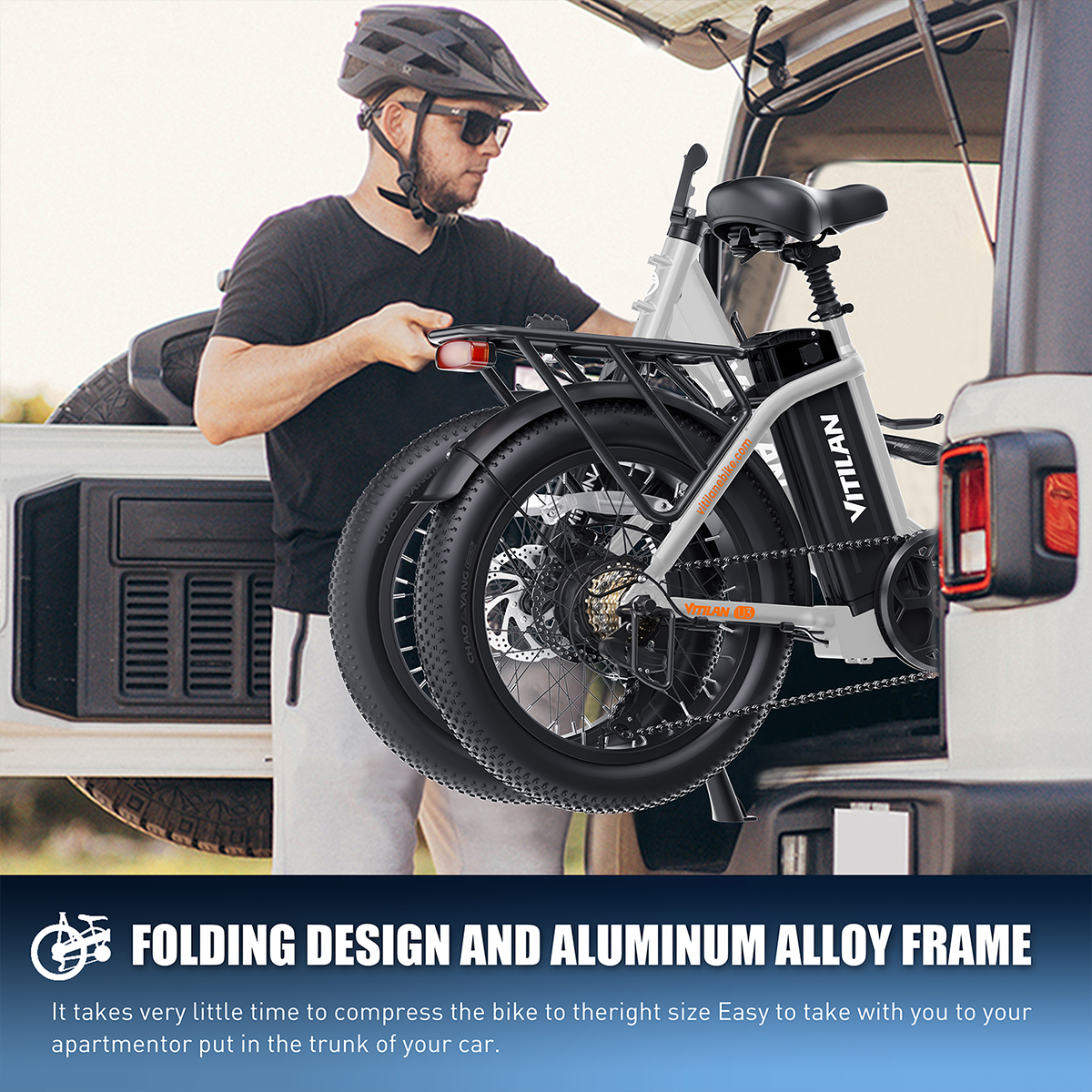 Mężczyzna wyjmuje rower elektryczny z bagażnika. Rower jest szary z czarnymi oponami.