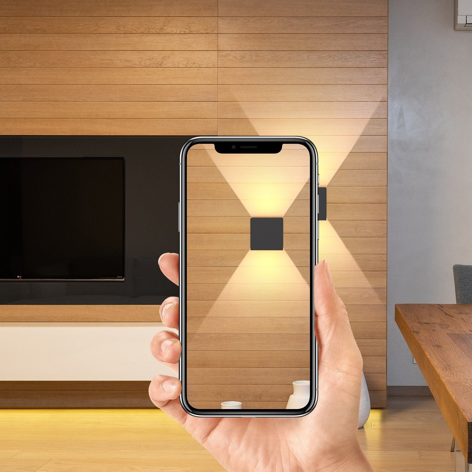 Ręka trzymająca telefon pokazujący ścianę z dwoma światłami.