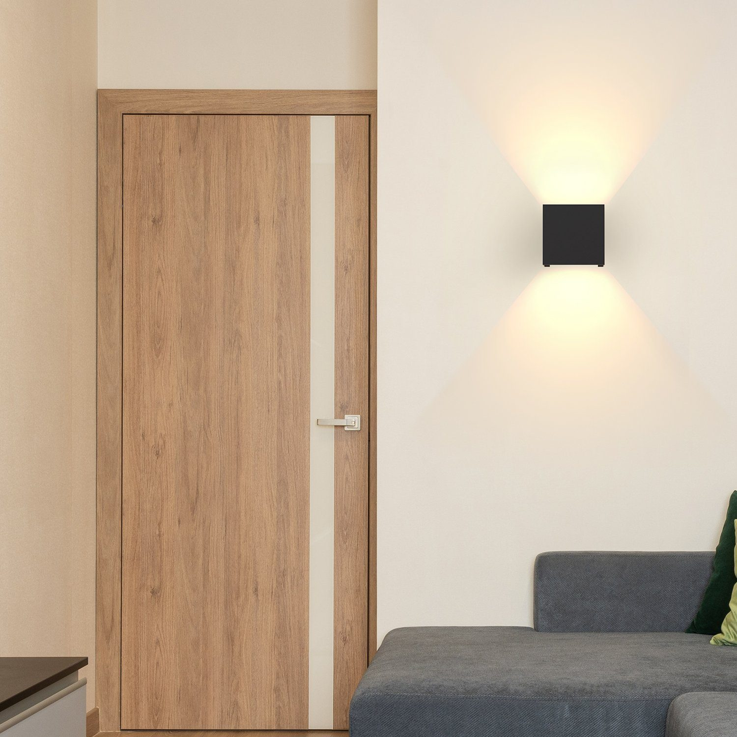 Interno: porta in legno con una striscia bianca e un apparecchio di illuminazione nero quadrato a parete.