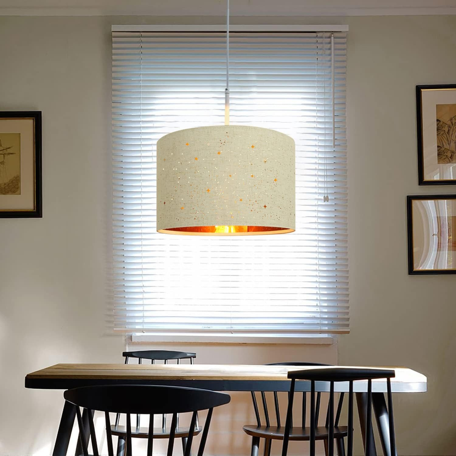 Cylindryczny klosz wiszący u sufitu, pod nim stół jadalny i krzesła.