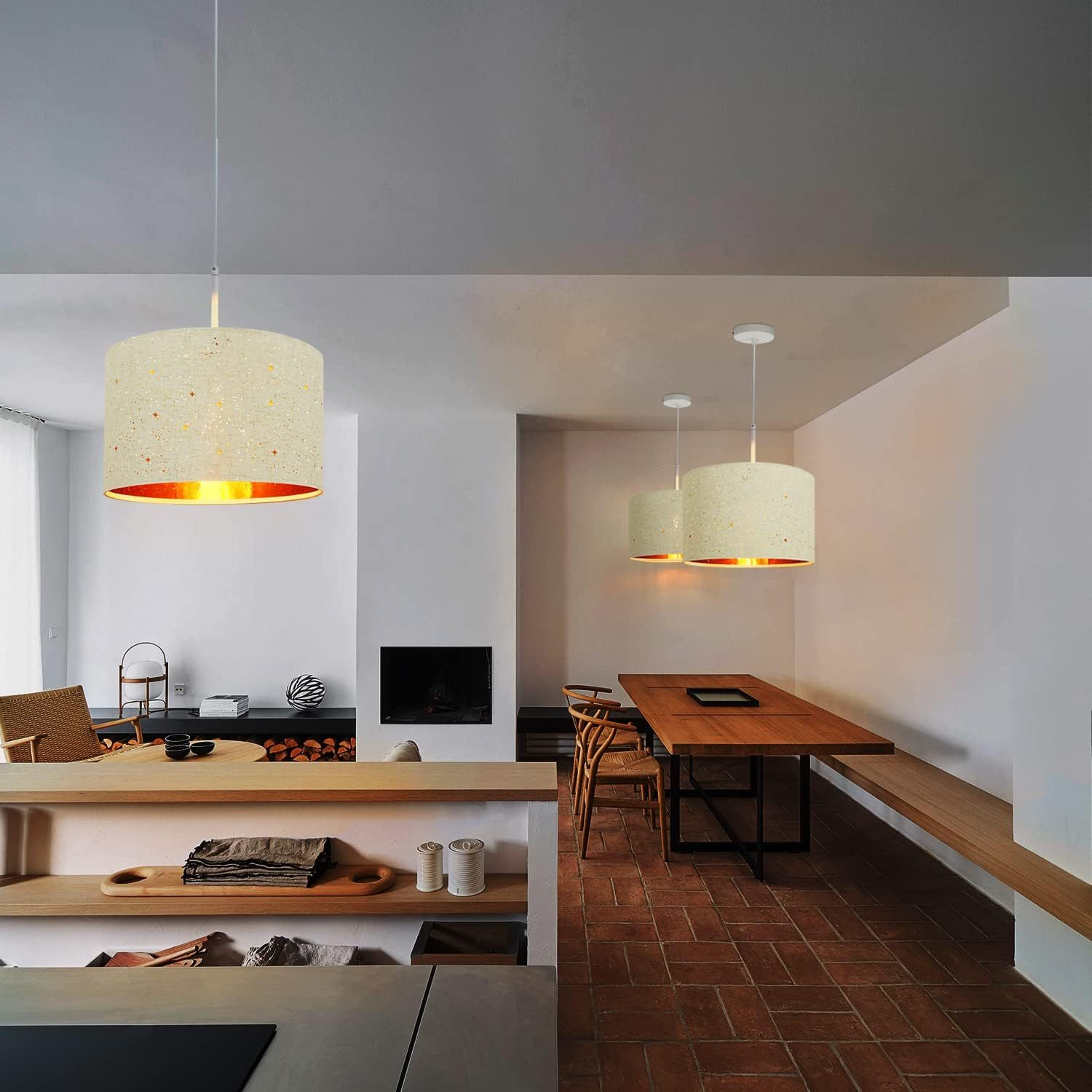 Trzy lampy wiszące w pokoju. Pokój obejmuje stół jadalny i kominek.