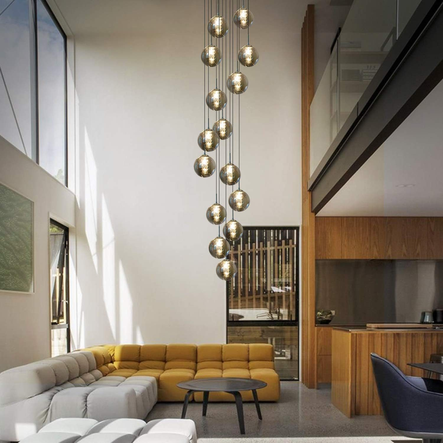 Nowoczesne wnętrze z wysokim sufitem i wiszącą lampą z wieloma żarówkami.
