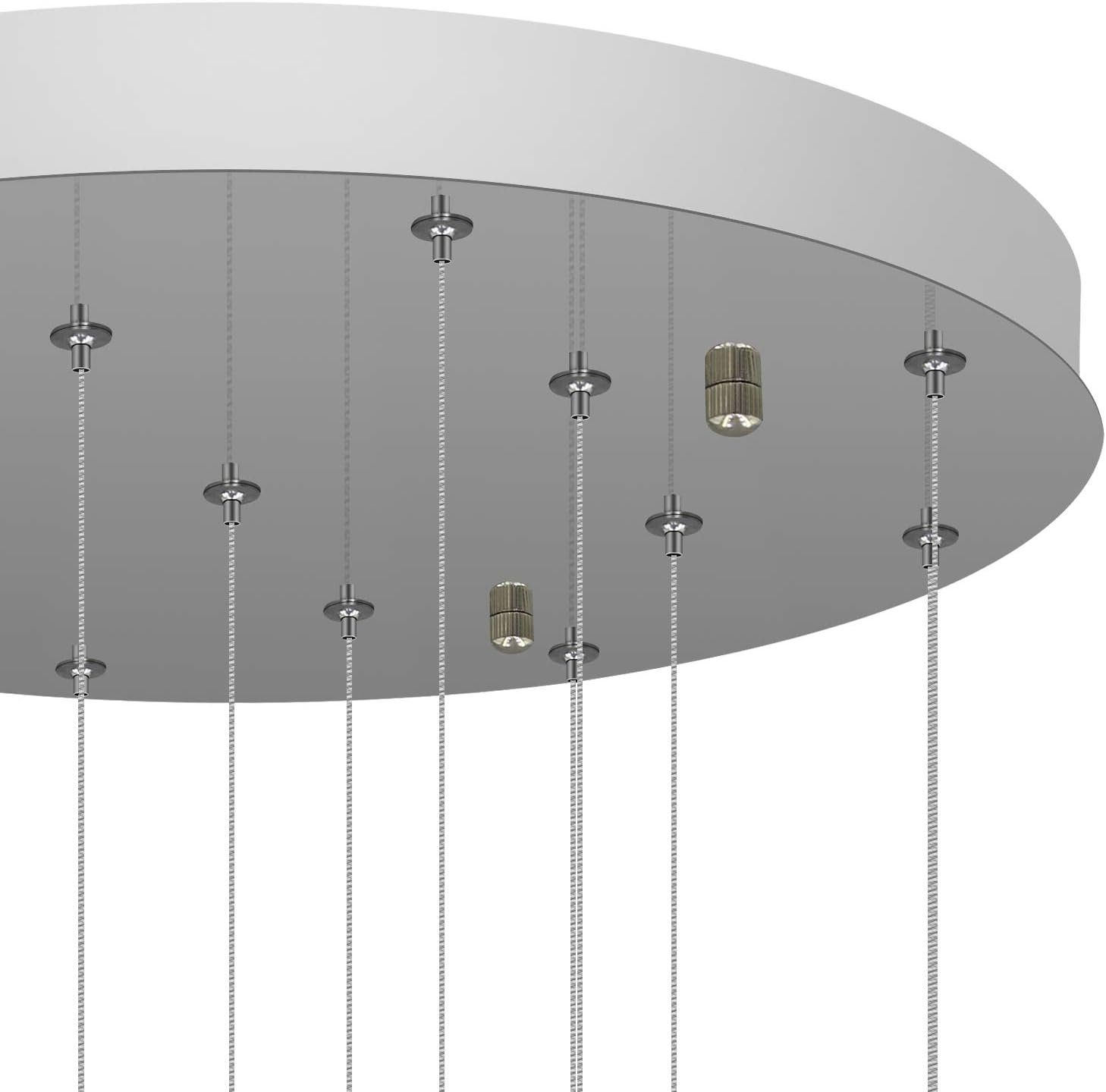 Zbliżenie białego sufitu ze srebrnymi przewodami i złotymi oprawami oświetleniowymi.