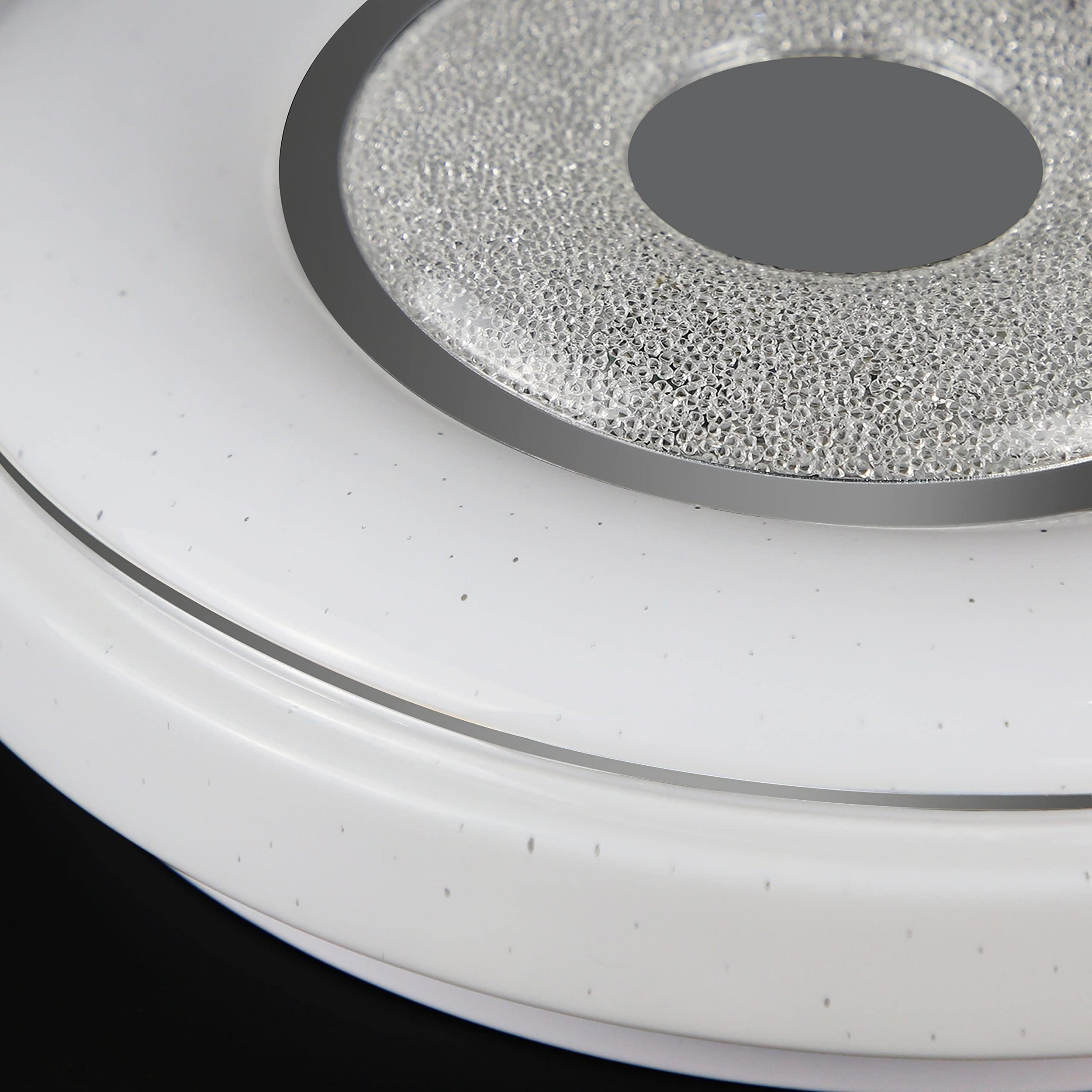 Zbliżenie białej lampy sufitowej z okrągłym wzorem i centralnym obszarem wypełnionym kryształkami.