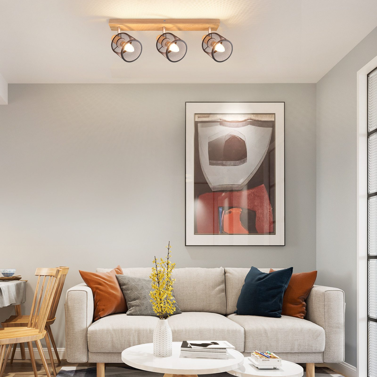 Salon z kanapą i oprawą oświetleniową. Oprawa ma trzy światła.