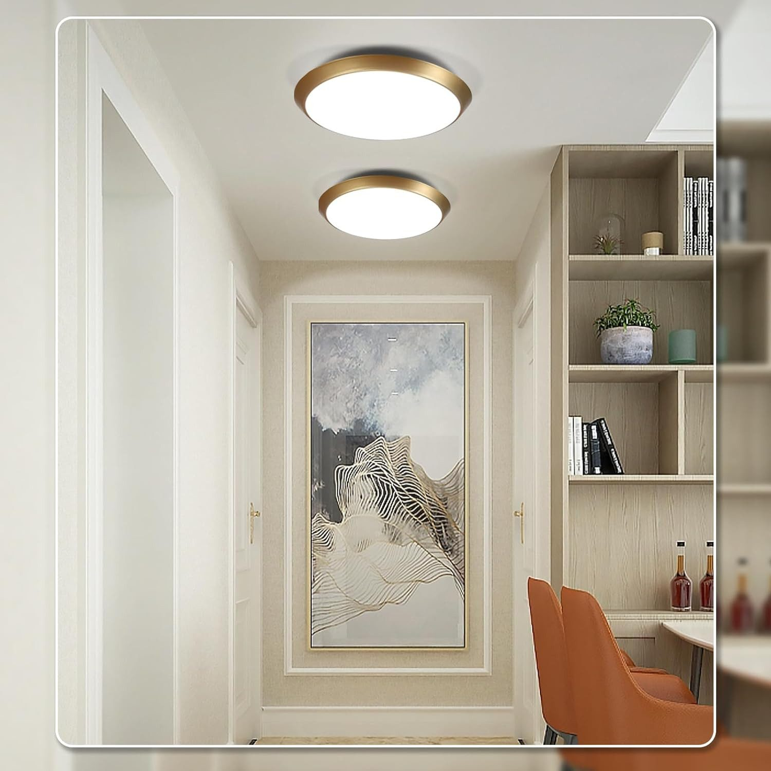 Wewnętrzny korytarz z dwoma lampami sufitowymi i oprawionym dziełem sztuki oraz widokiem na półkę z książkami.