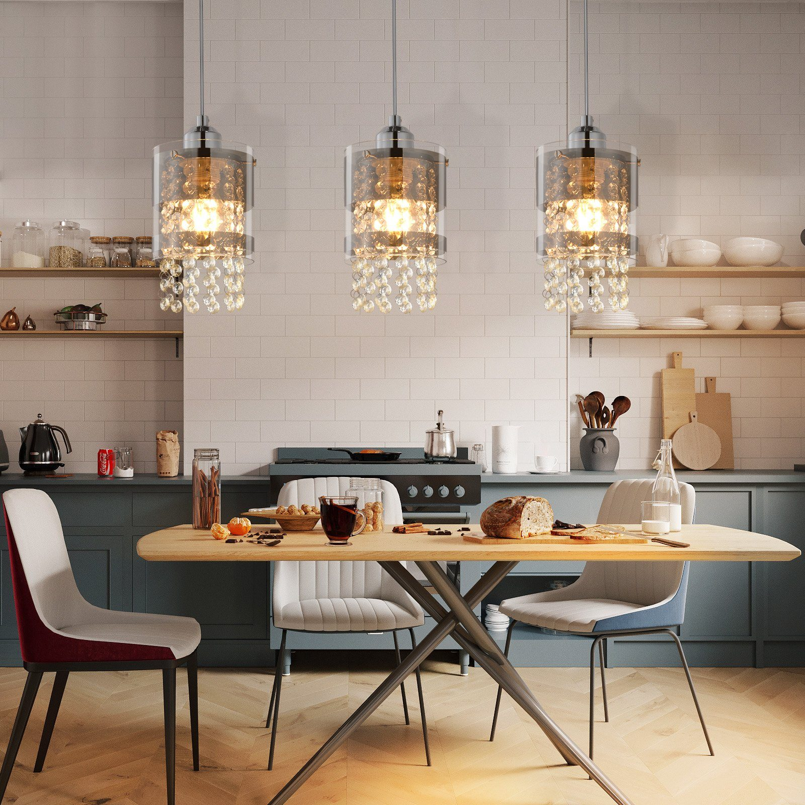 Trzy kryształowe żyrandole wiszą nad stołem nakrytym do posiłku w kuchni.