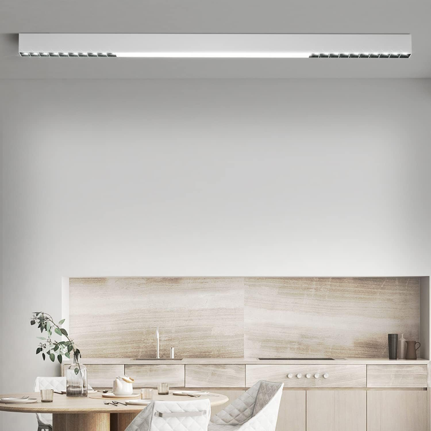 Nowoczesna kuchnia z białymi szafkami i drewnianym stołem. Liniowa oprawa oświetleniowa i dekoracja.