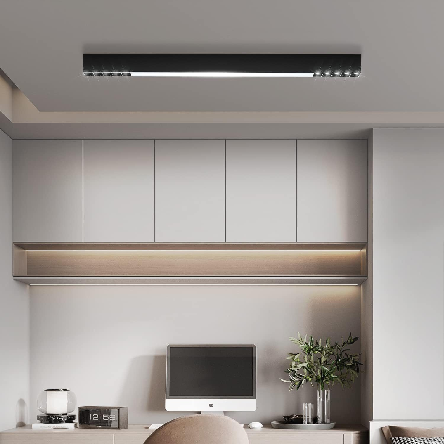 Długa, czarna, nowoczesna lampa sufitowa na białym suficie. Szafki i komputer w tle.