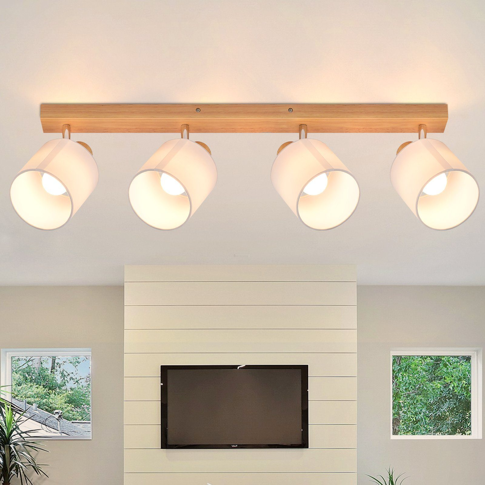 Salon z drewnianą belką i czterema białymi lampami. Telewizor poniżej, białe ściany i okno po prawej.