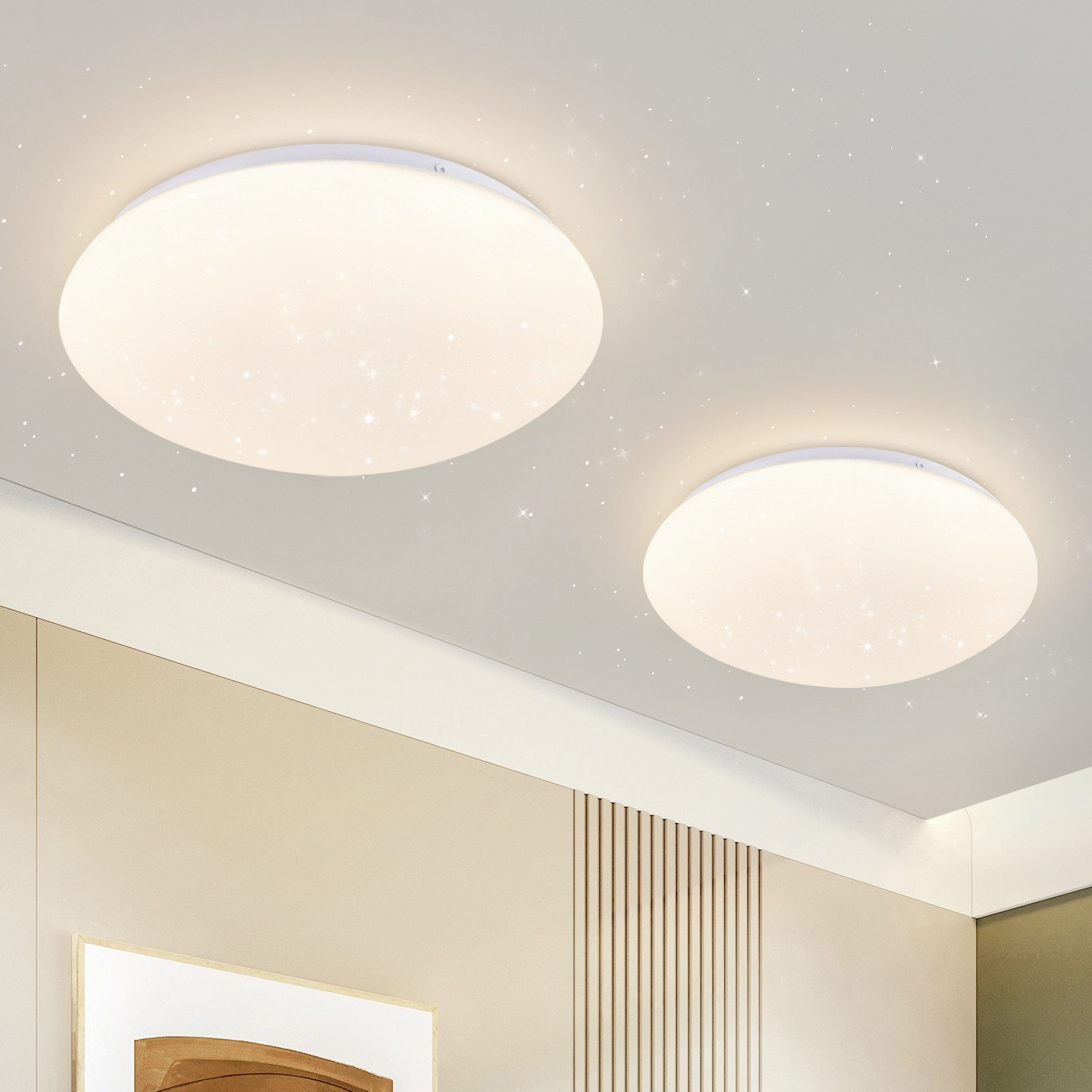 Dwie białe lampy sufitowe z wzorami w kształcie gwiazd. Są okrągłe i oświetlają sufit.