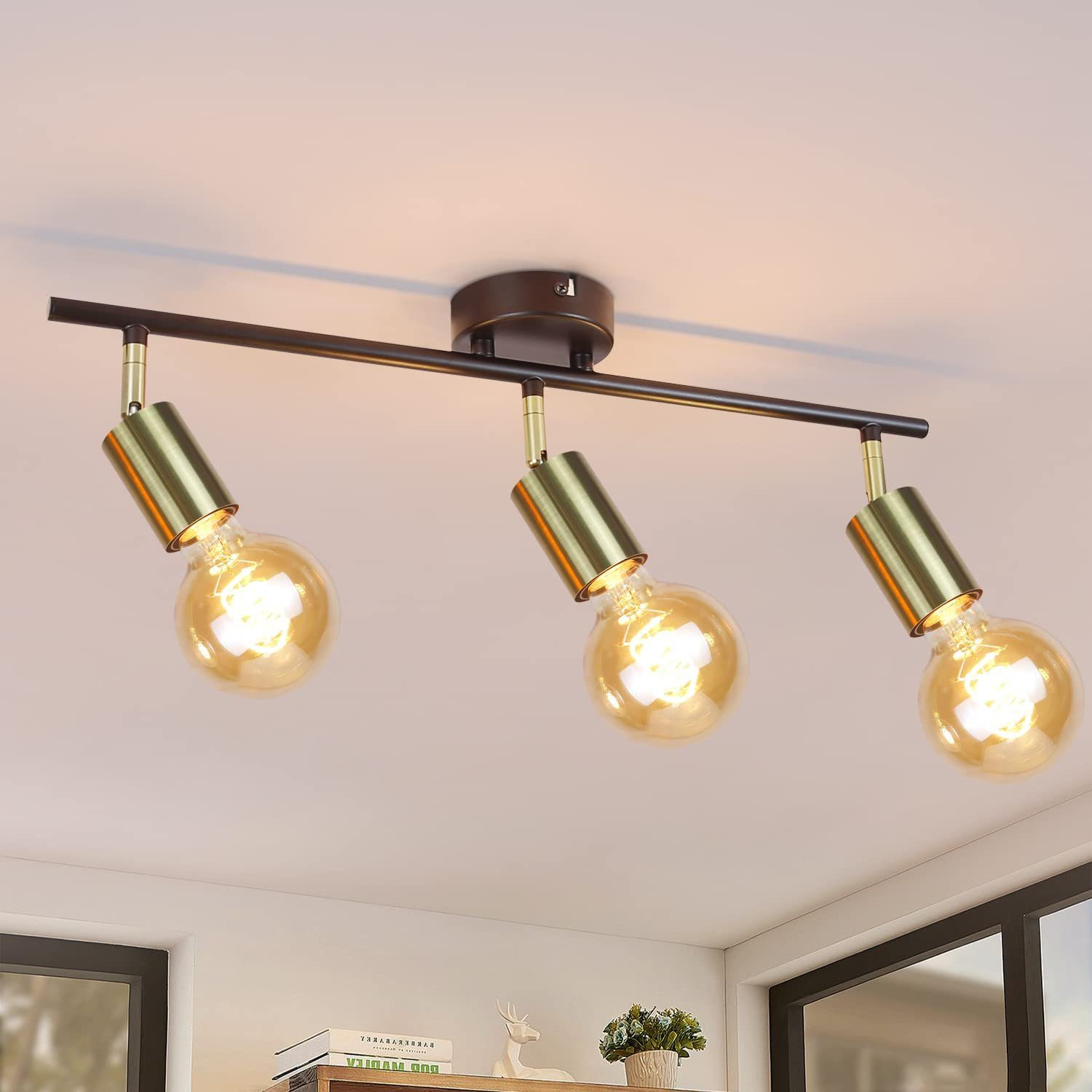 Trzy lampy sufitowe, złote klosze, czarny pasek. Żółte żarówki.