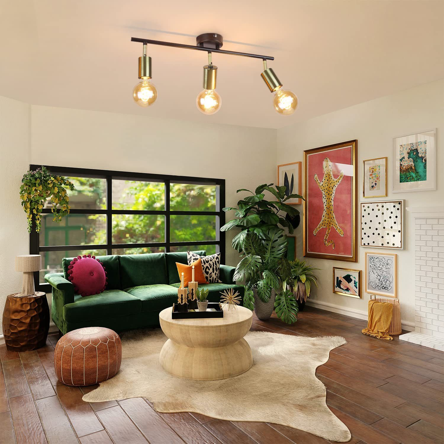 Salon z zieloną sofą, dywanem i oświetleniem szynowym z trzema żarówkami.