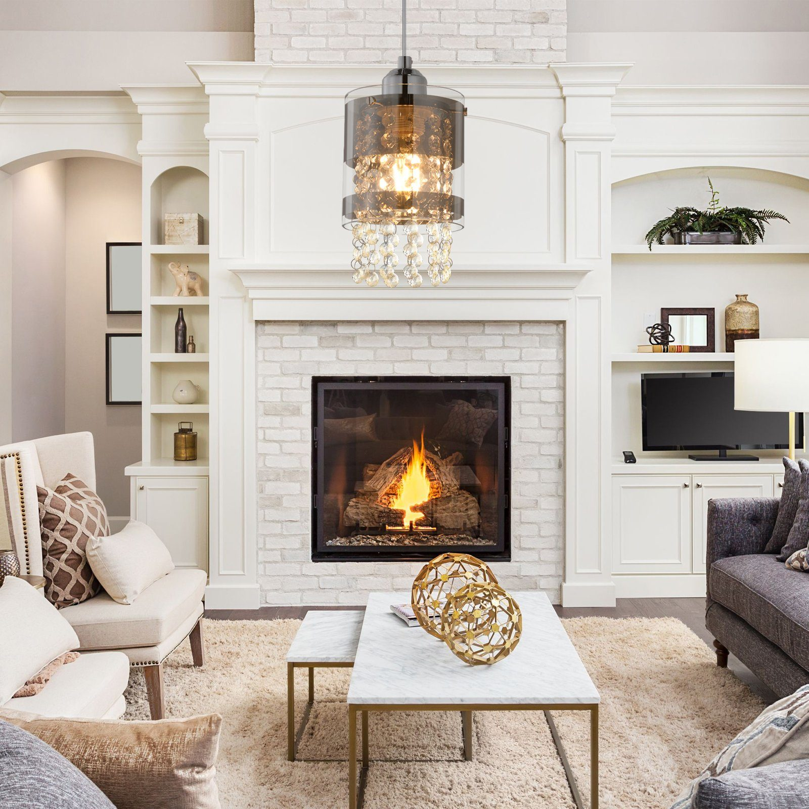 Wnętrze salonu z kominkiem i zwisającym żyrandolem.