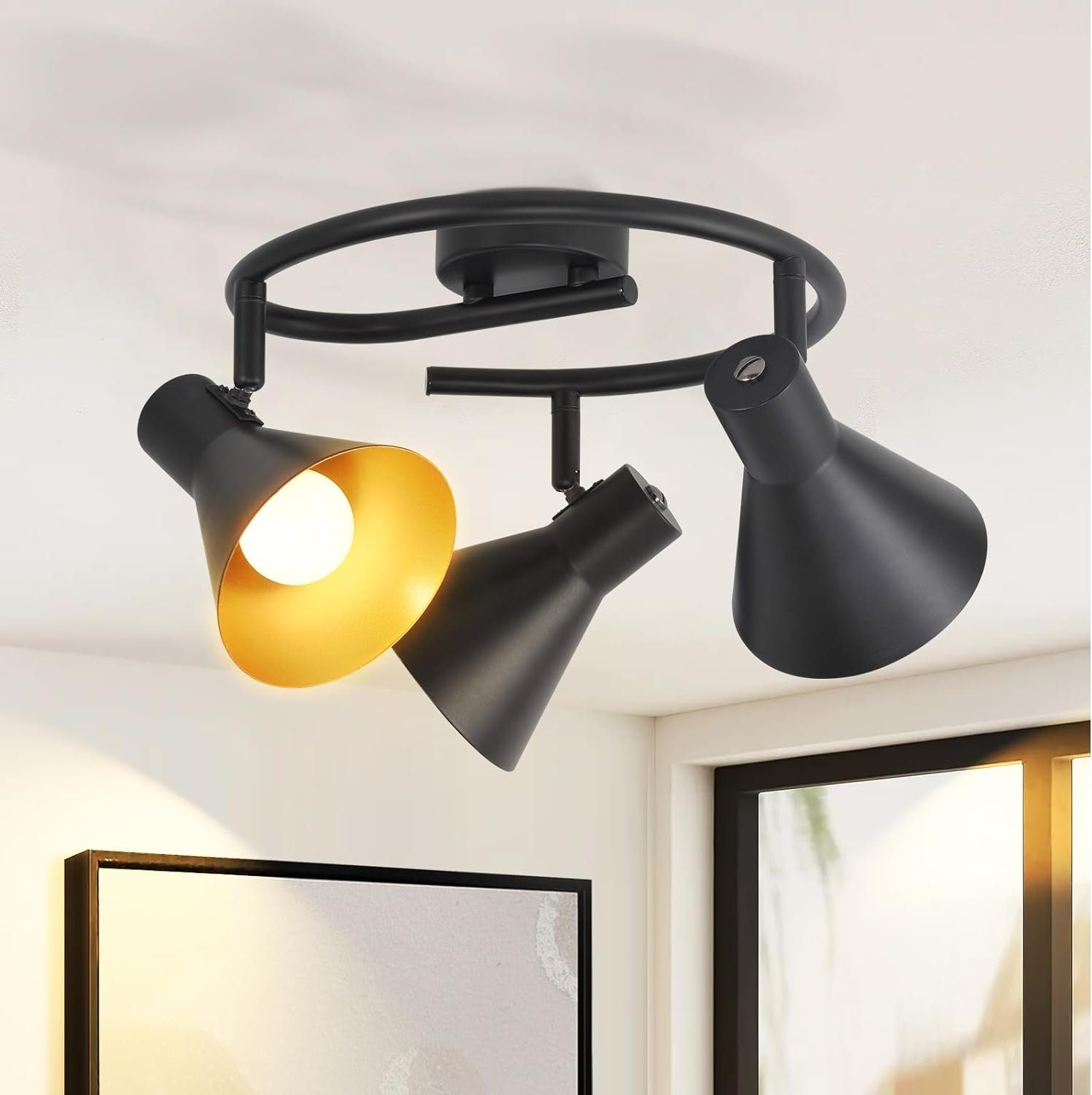 Trzy czarne reflektory na okrągłym torze, zamontowane na białym suficie. Głowice są ustawione pod kątem.
