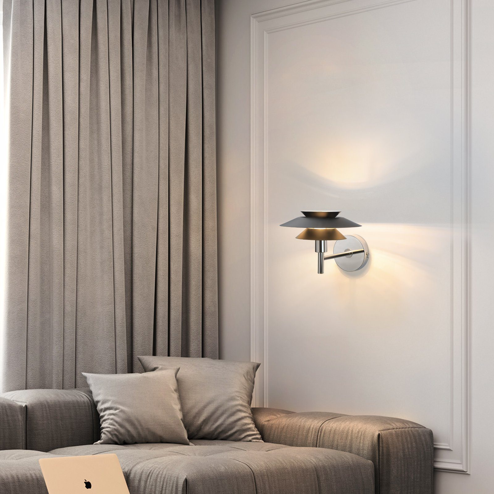 Kinkiet z dwoma abażurami nad szarą sofą. Na sofie znajduje się laptop.