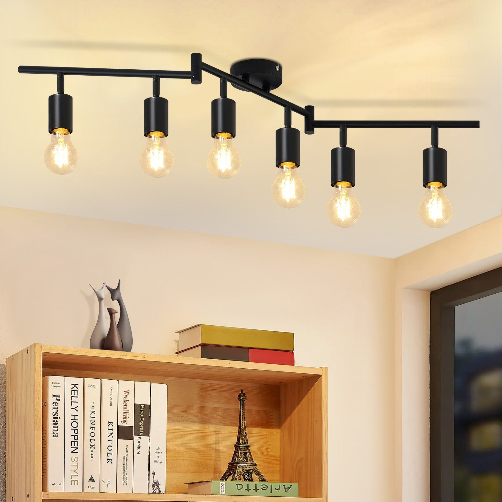 Czarna lampa sufitowa z sześcioma żarówkami, drewniana półka z książkami i dekoracjami.