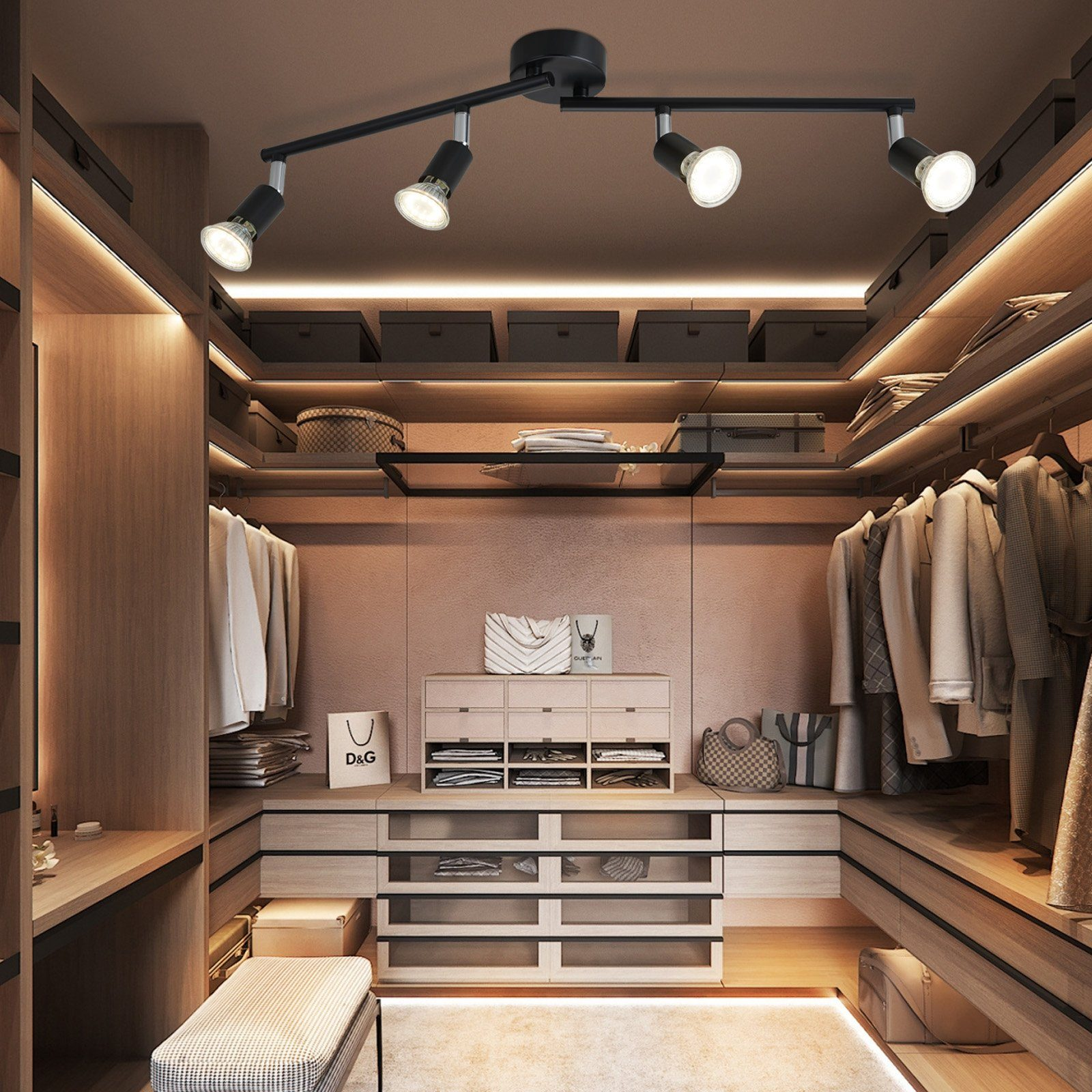 Garderoba z oświetleniem szynowym. Beżowe ściany, drewniane półki z ubraniami, szuflady i ławka.