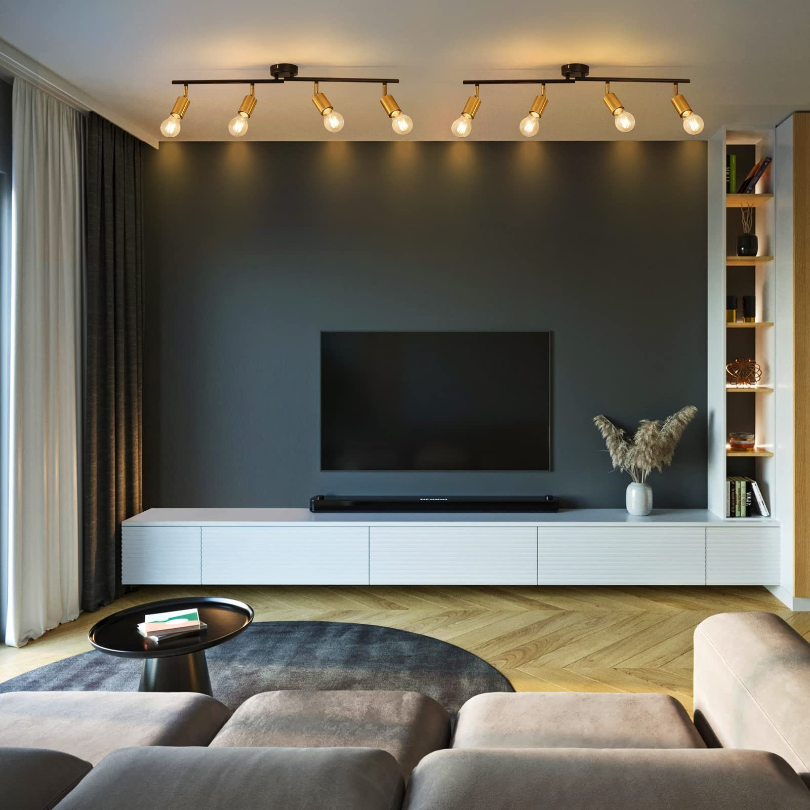 Salon z telewizorem, sofą i dywanem. Na suficie są reflektory szynowe.