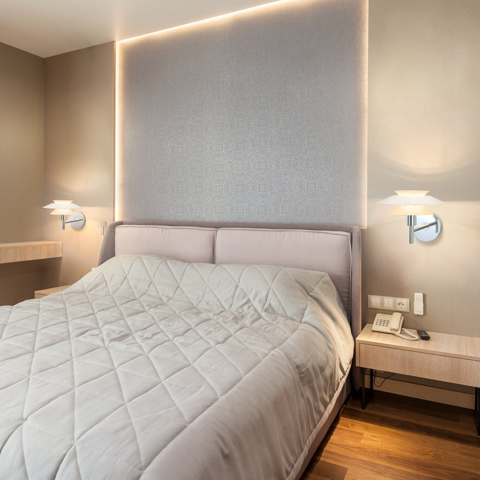 Sypialnia z łóżkiem i lampami ściennymi. Łóżko ma białą, pikowaną narzutę.