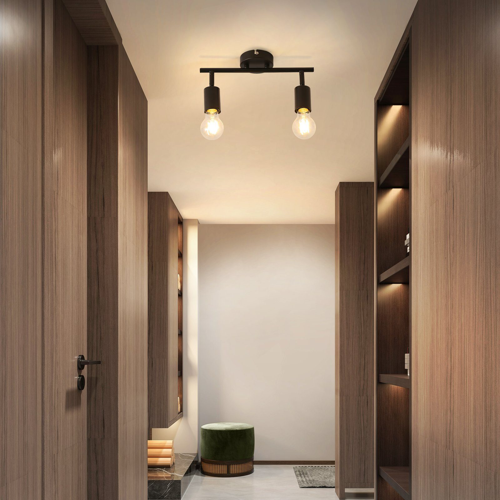 Flur mit zwei Leuchten, Holztüren, weißer Wand und grünem Hocker.