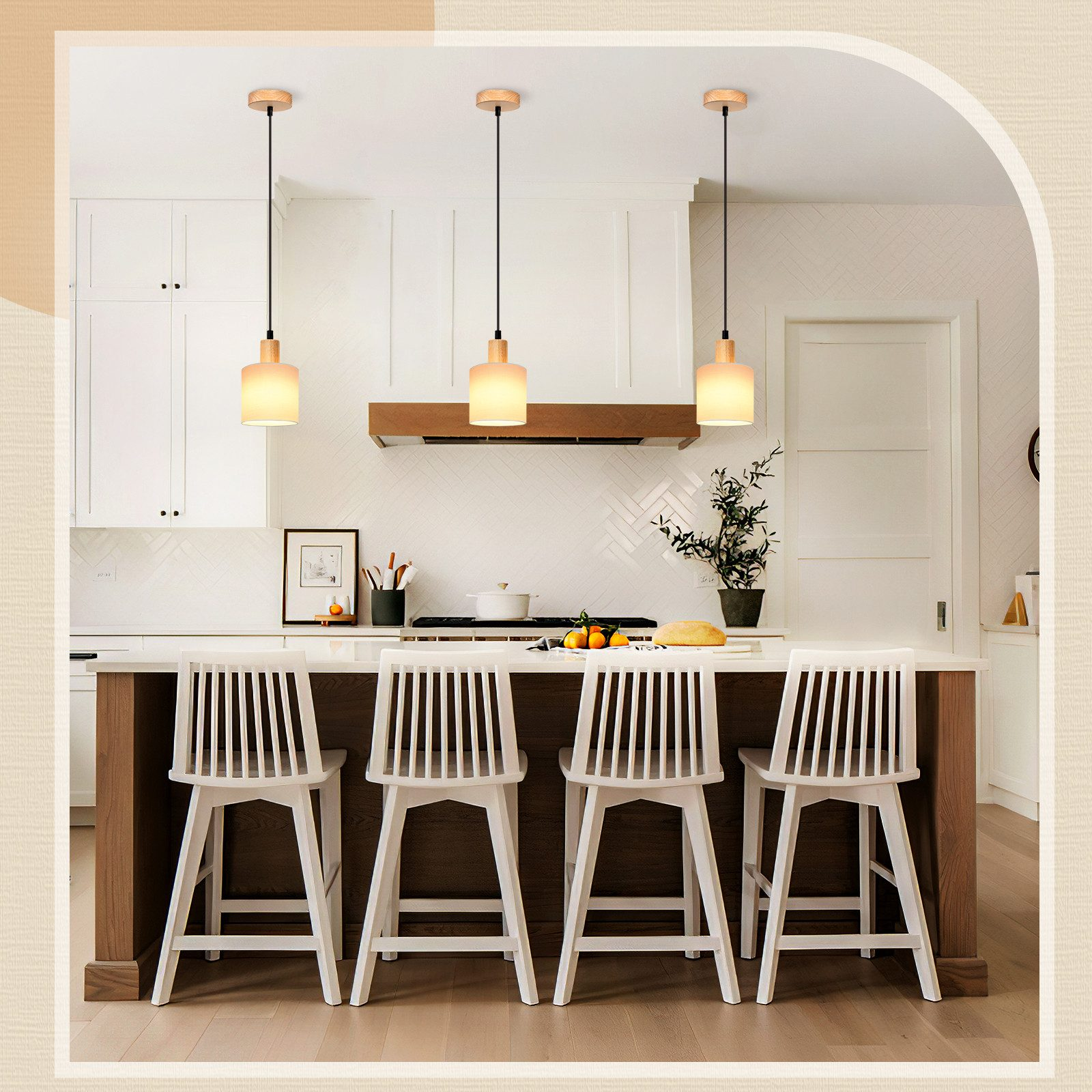 Eine moderne Küche mit Pendelleuchten über einer Insel mit Hockern. Weiße Schränke und eine Holzhaube vervollständigen den Look.