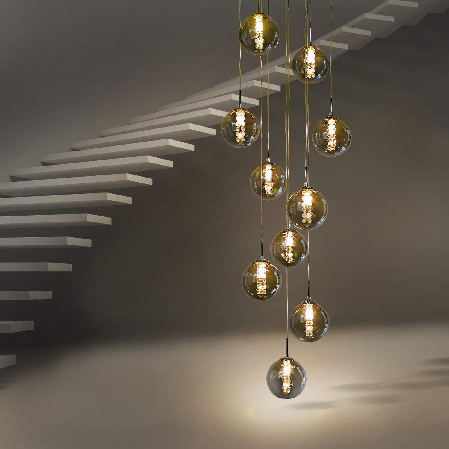 Klatka schodowa z kulistymi lampami szklanymi zwieszonymi z sufitu. Białe schody po lewej.