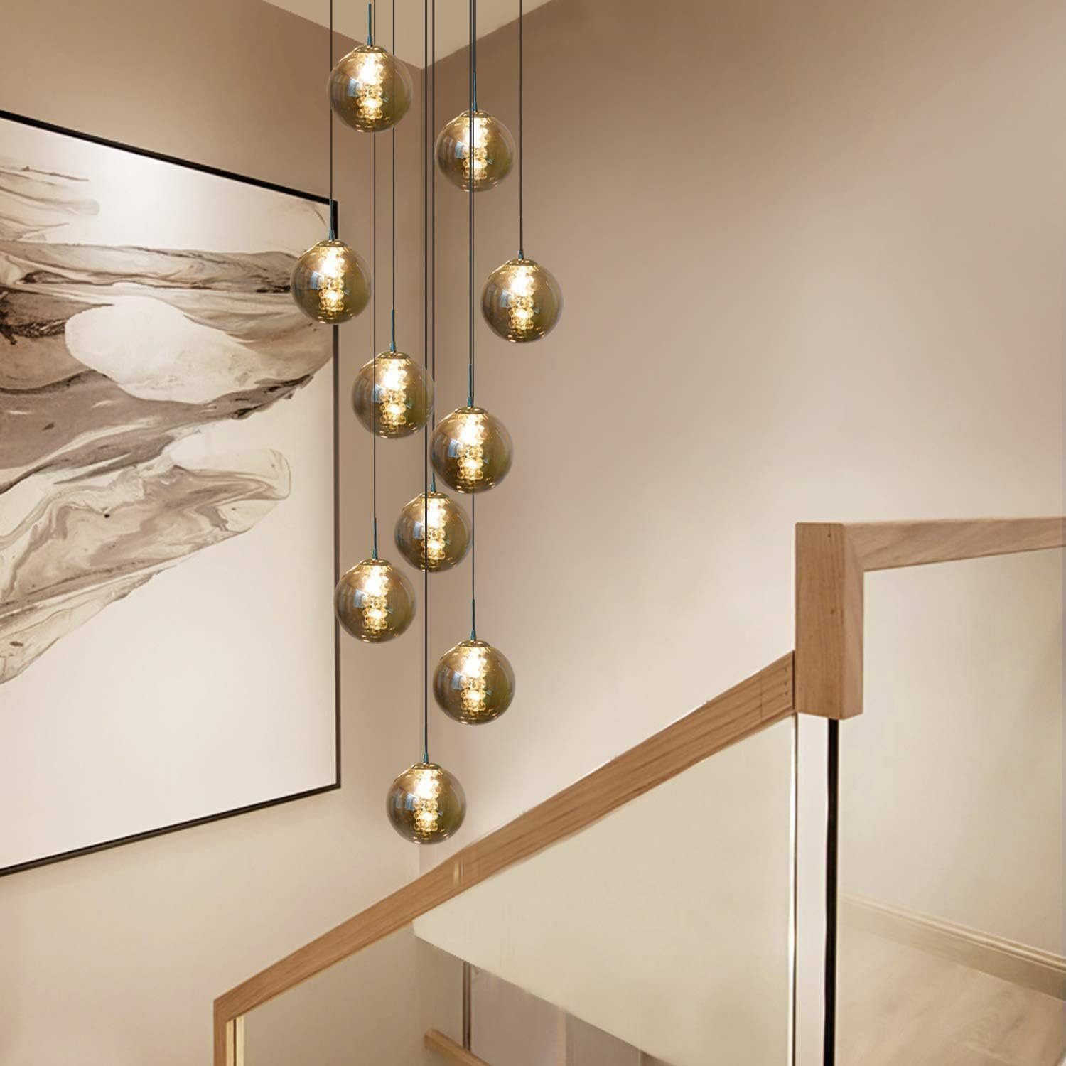 Schody z żyrandolem z szklanych kul i obrazem na ścianie.