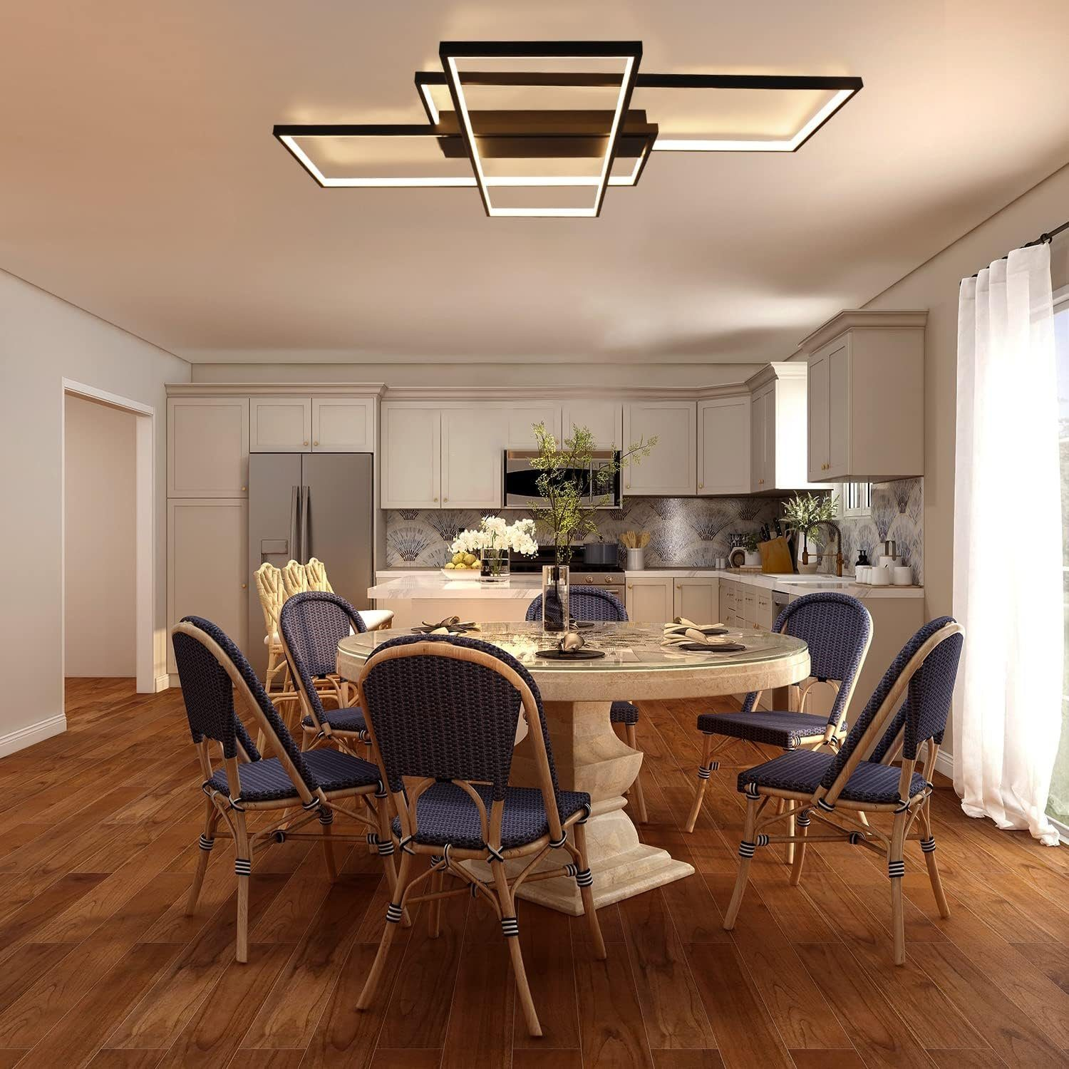 Sala da pranzo con tavolo rotondo, sedie blu e lampada moderna. Cucina sullo sfondo.