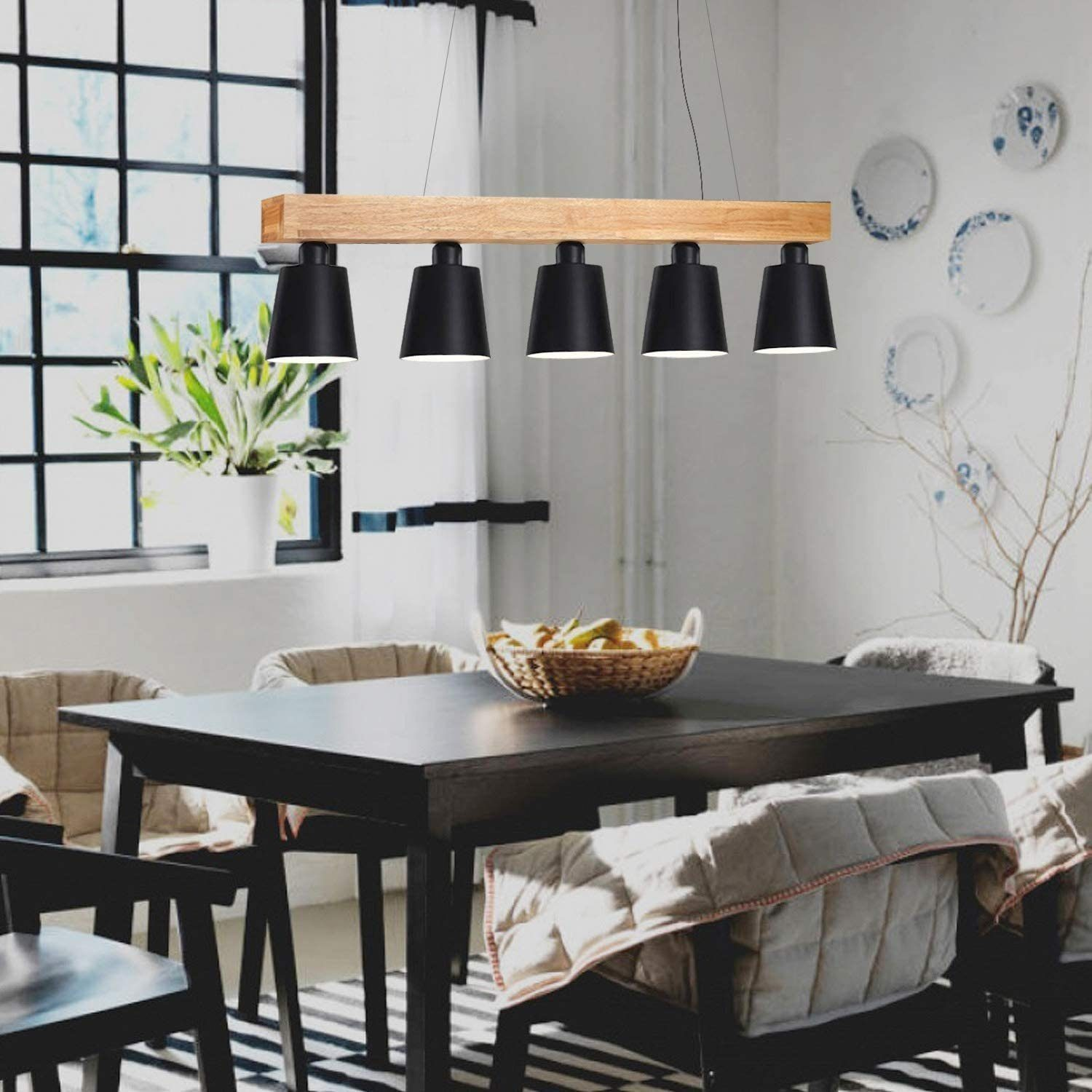 Jadalnia z czarnym stołem i krzesłami oraz oprawą oświetleniową.