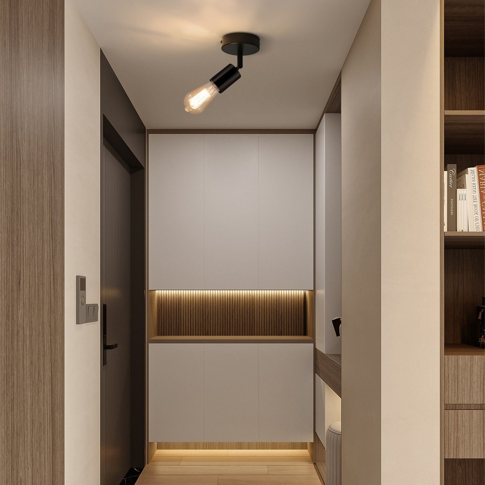 Un corridoio con una luce a soffitto. C'è una porta e alcuni mobili in legno.