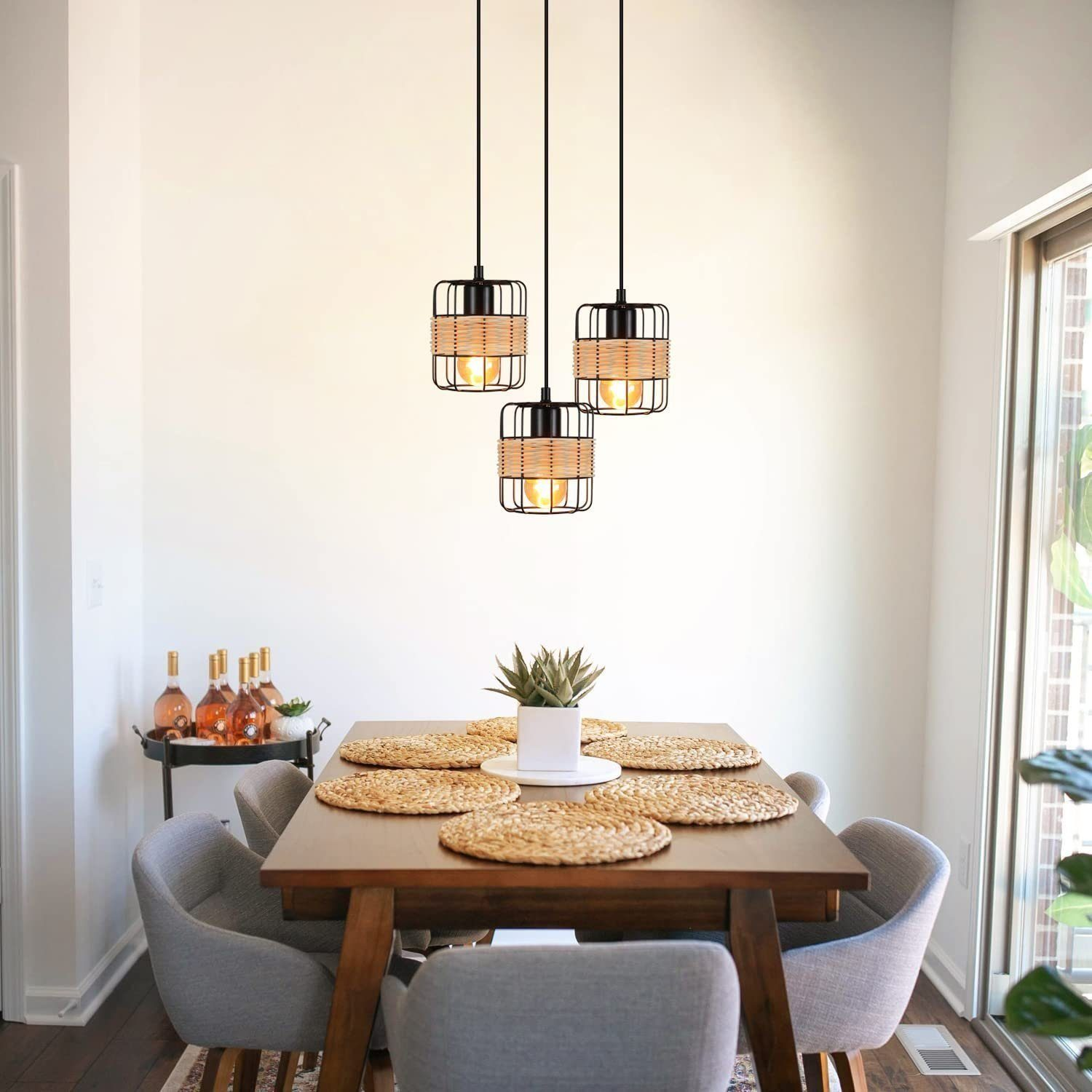 Trzy lampy wiszące nad stołem jadalnym. Nakrycie stołu, krzesła i biała ściana w scenie.