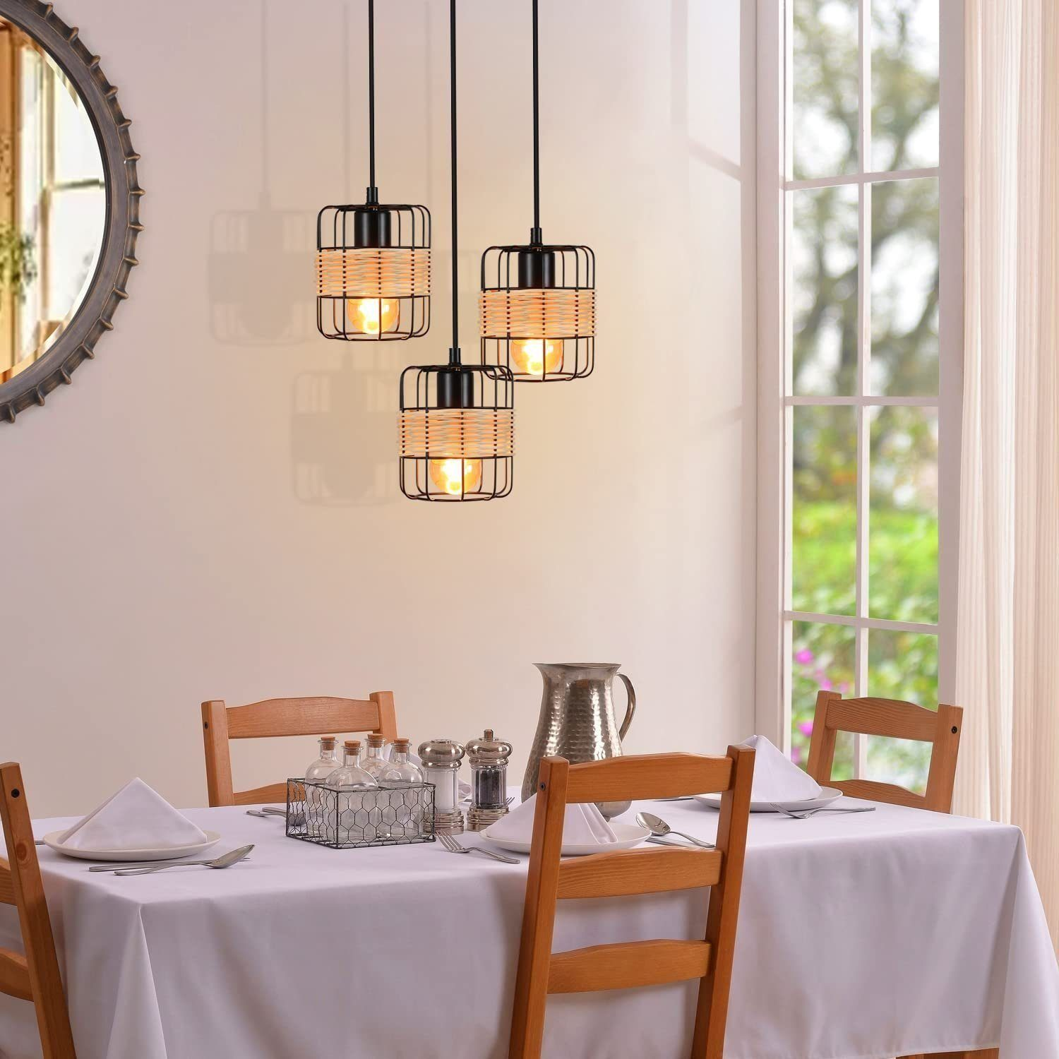 Trzy lampy wiszące z kloszami w kształcie klatek nad stołem.
