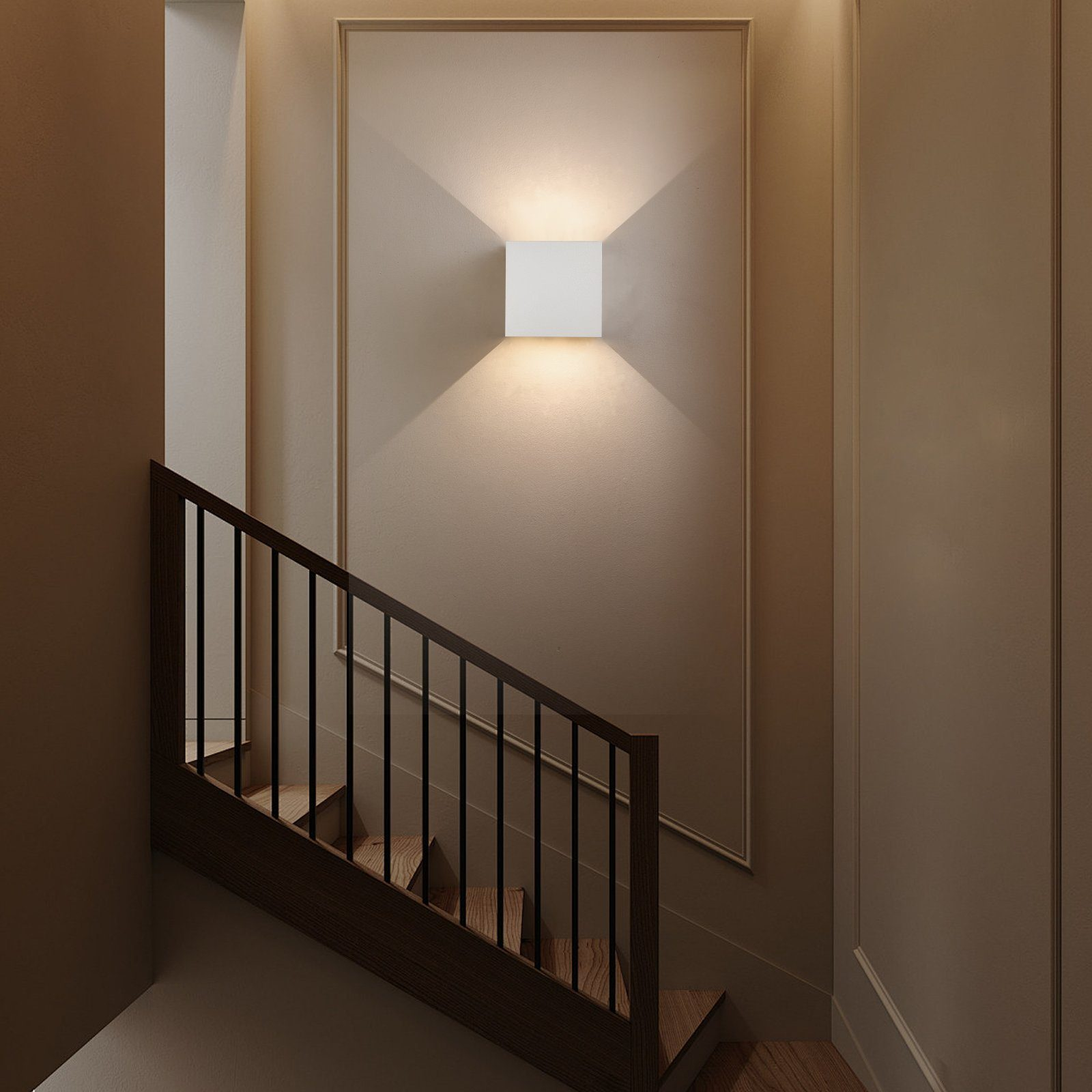 Klatka schodowa z białą ścianą, białym kwadratowym światłem i ciemnymi drewnianymi schodami z czarną balustradą.