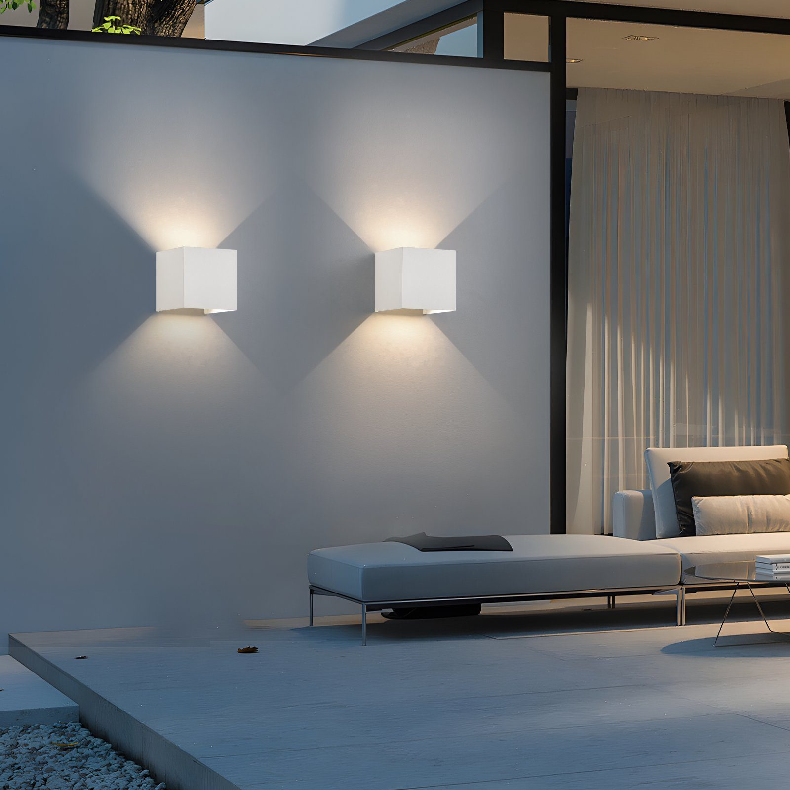 Due lampade da parete quadrate bianche illuminano un muro grigio.