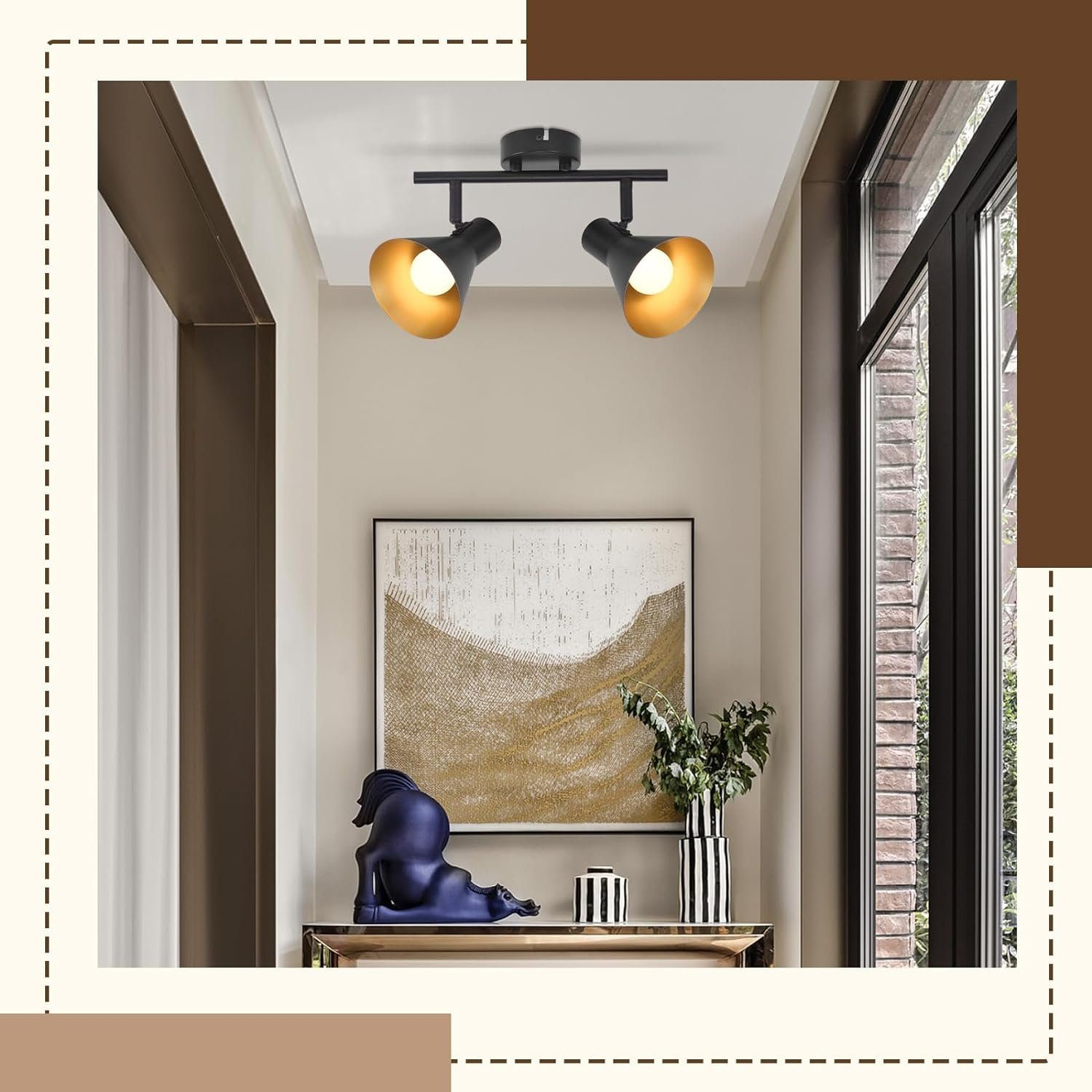 Korytarz z dziełem sztuki, konsolą i dwoma czarnymi reflektorami na suficie.