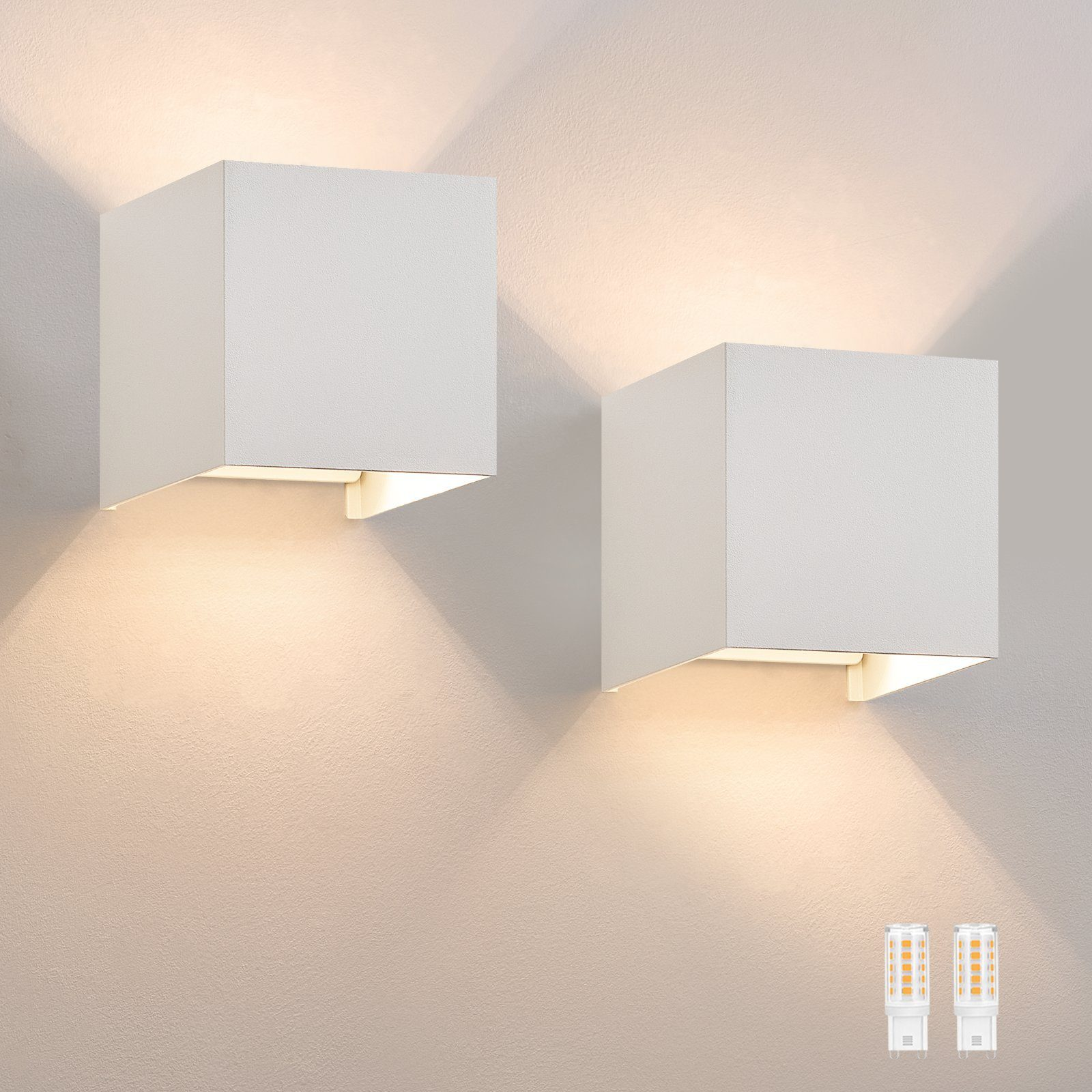 Dwie białe, sześcienne lampy ścienne, oświetlające ścianę poniżej. Poniżej pokazano dwie żarówki.