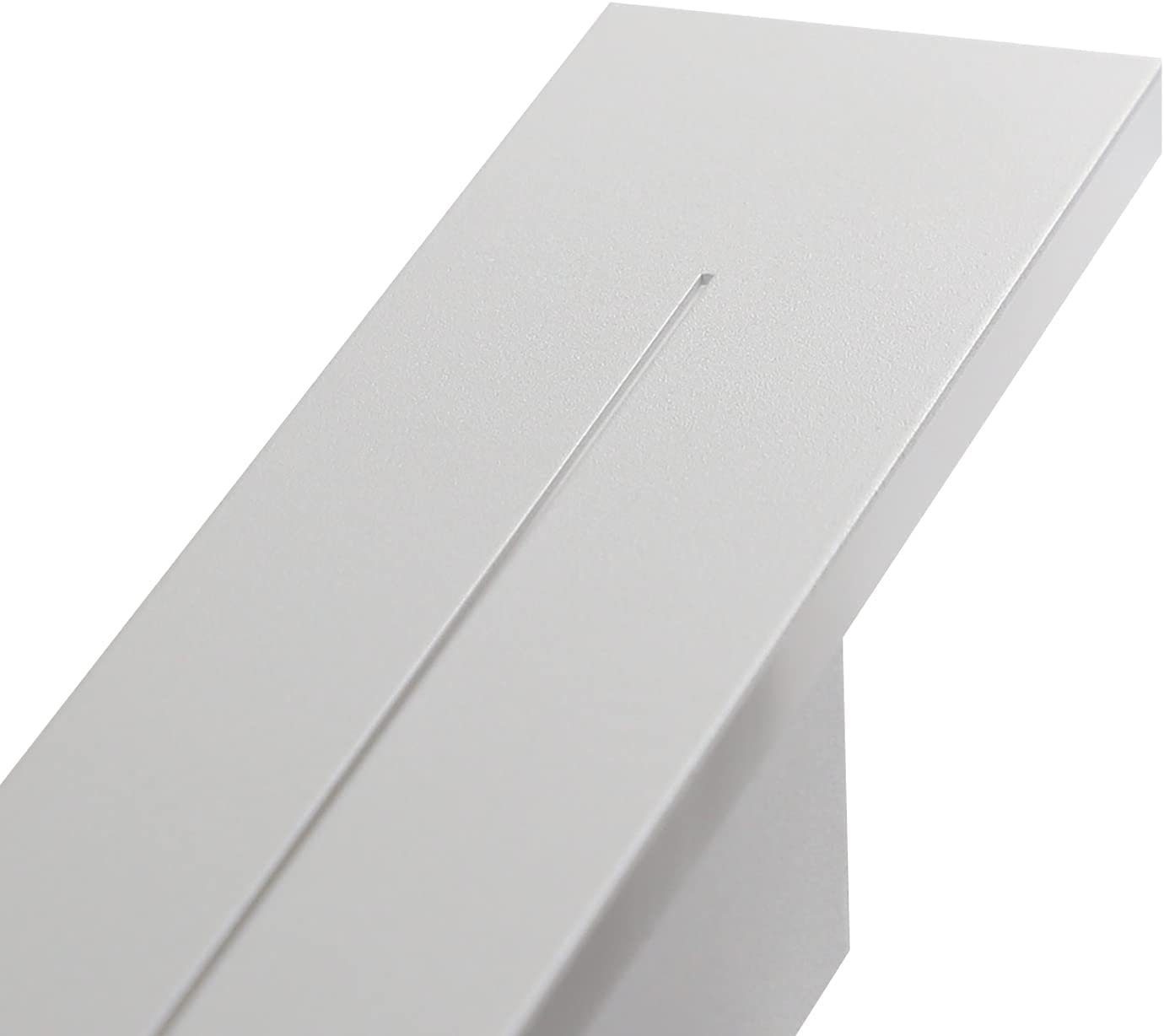 Zbliżenie białego, kątowego elementu architektonicznego z wąskim rowkiem.