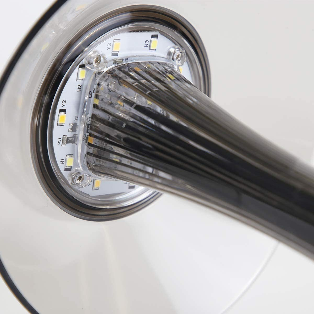 Zbliżenie nowoczesnego projektu lampy, pokazujące światła LED i przezroczyste, cylindryczne wsparcie.