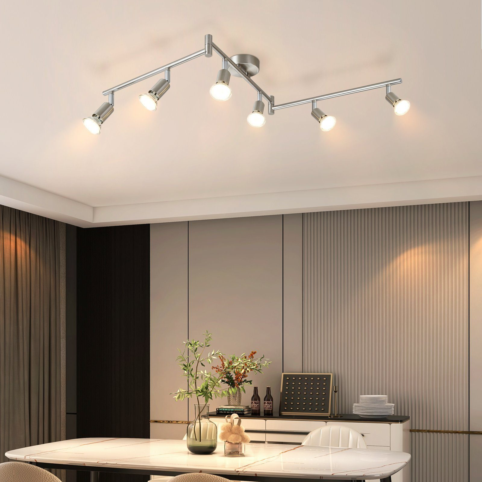 Jadalnia z sześcioma srebrnymi reflektorami na suficie. Stół i krzesła na pierwszym planie.