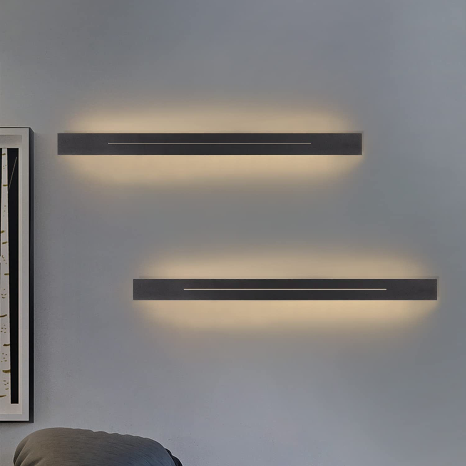 Zwei rechteckige Wandleuchten, die warmes Licht ausstrahlen, an einer grauen Wand montiert.