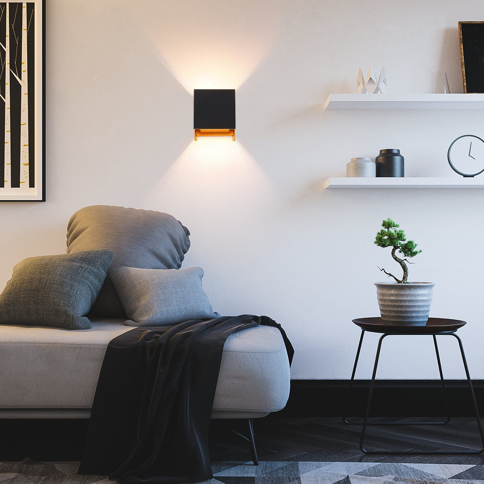 Czarna lampa ścienna z efektem reflektora. Bonsai stoi na stole.