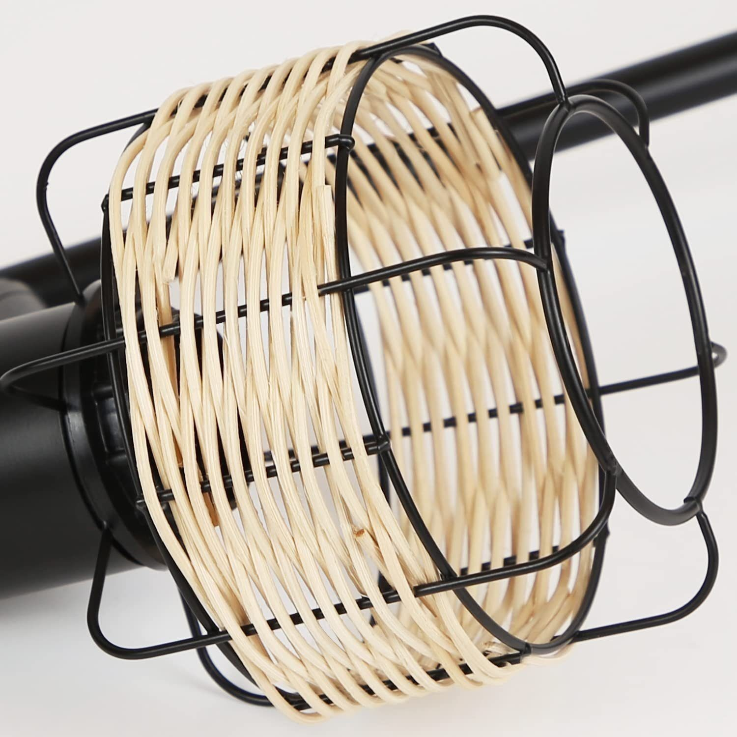 Zbliżenie czarnej lampy z tkanym, beżowym, cylindrycznym kloszem. Czarna rama.