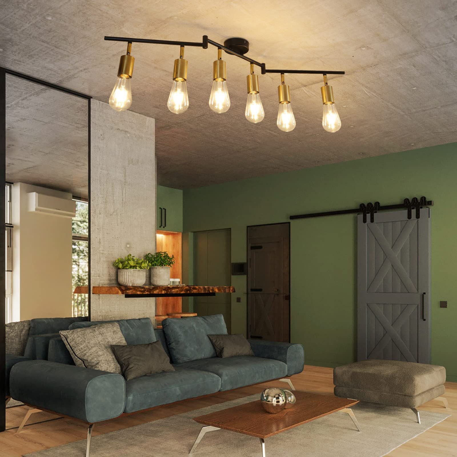 Soggiorno con divano verde acqua, tavolo in legno e lampada da soffitto nera e oro.