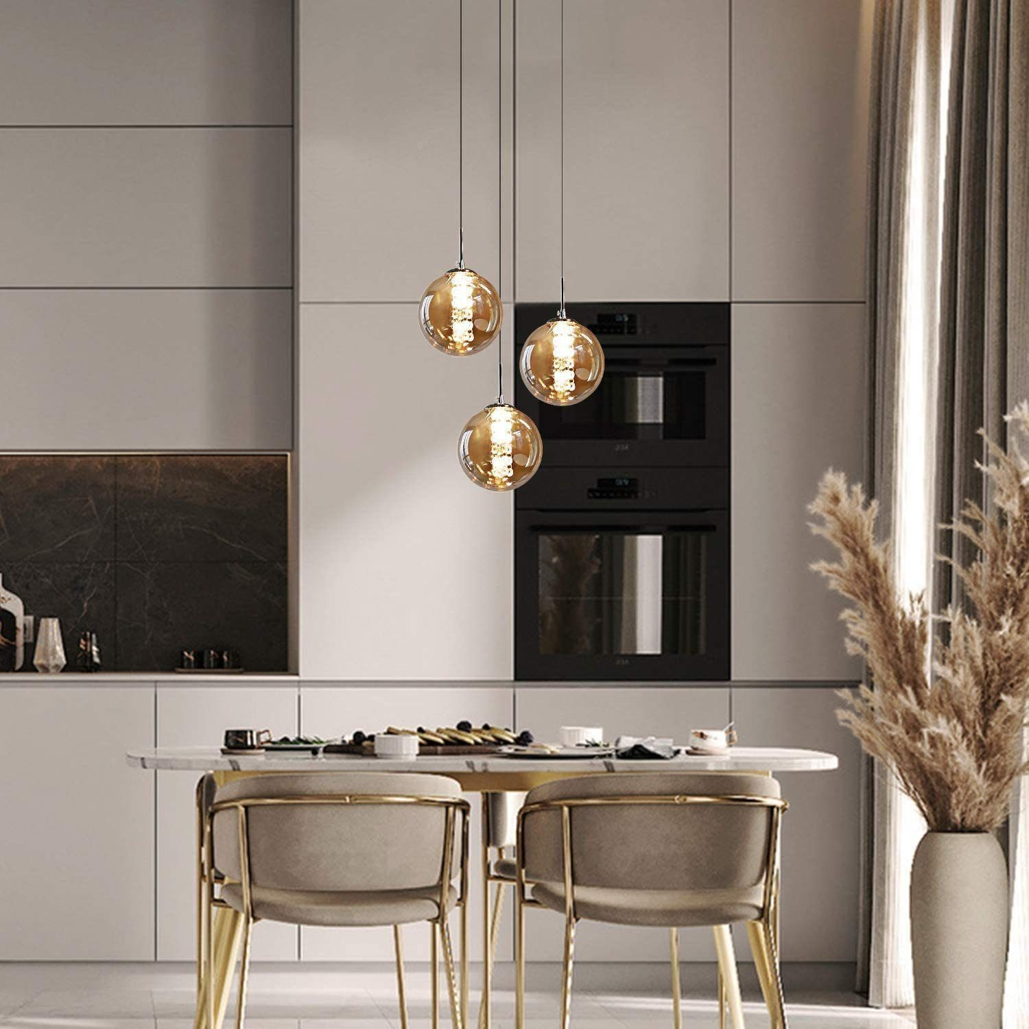 Trzy wiszące lampy kuliste wiszą w kuchni, z neutralną kolorystyką i nowoczesnym designem.