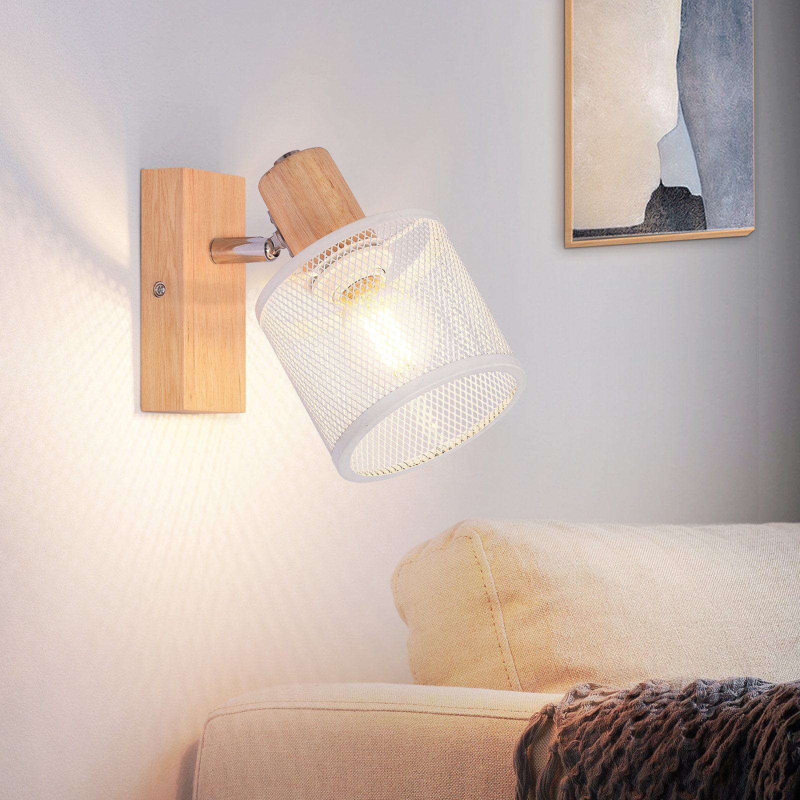 Lampa ścienna z białym, siatkowym kloszem i drewnianą podstawą. Jest zamontowana na ścianie nad sofą.